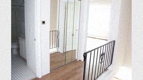 a hallway with a staircase and a door to a bathroom