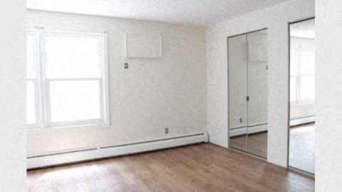 an empty room with a wood floor and a window