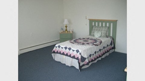 a bedroom with a bed and a night stand