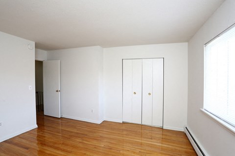 an empty room with white walls and a wood floor