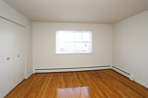 an empty room with wooden floors and a window