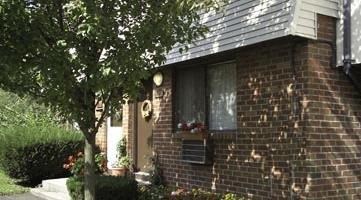 a brick house with a tree in front of it