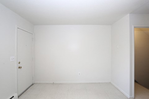 an empty room with a white wall and a door