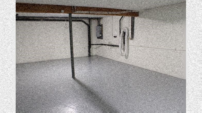 an empty garage with pipes and wires on the wall