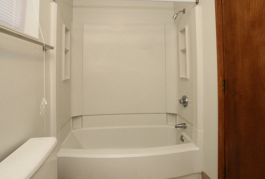a white bathroom with a bath tub and a shower curtain