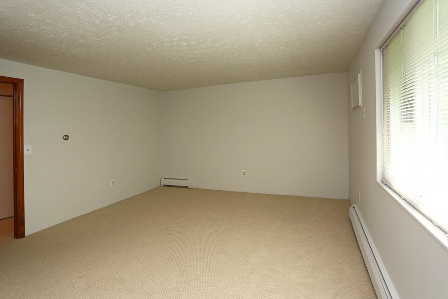 an empty room with a large window and white walls