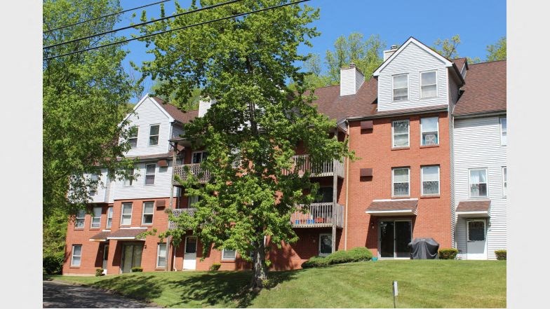 an apartment building with a tree in front of it