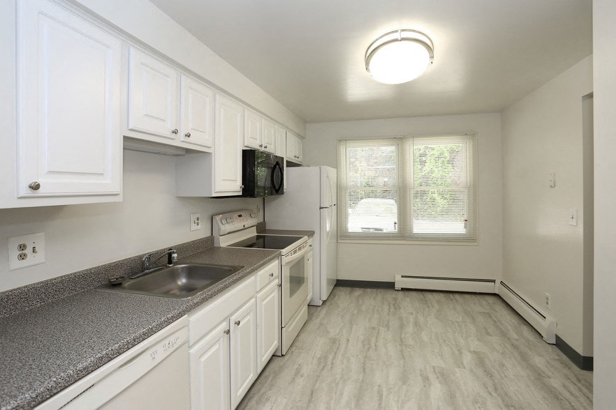 a kitchen with white cabinets and a sink and a refrigerator