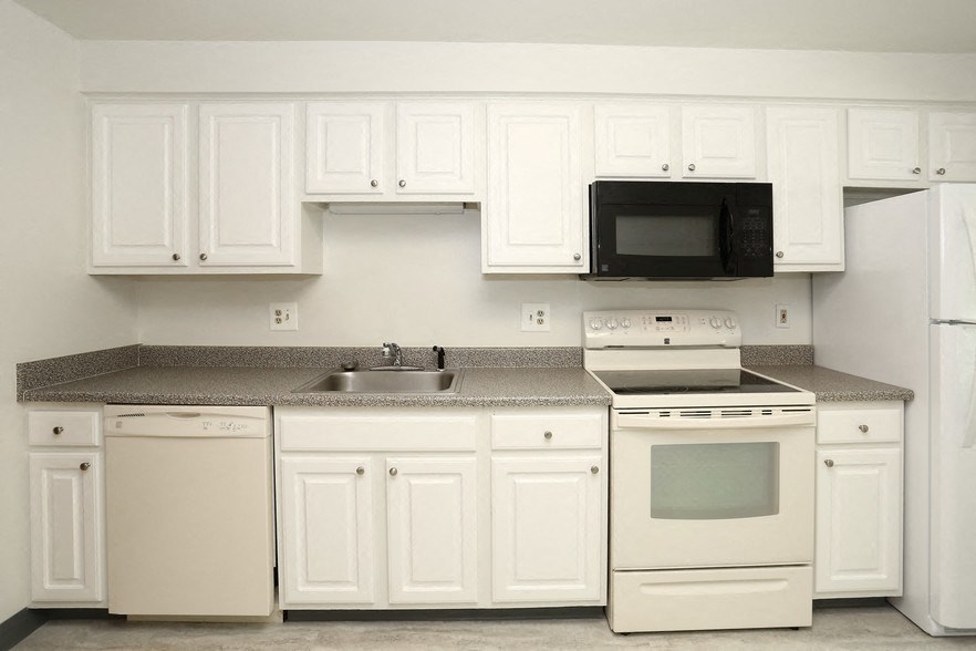 a kitchen with white appliances and white cabinets