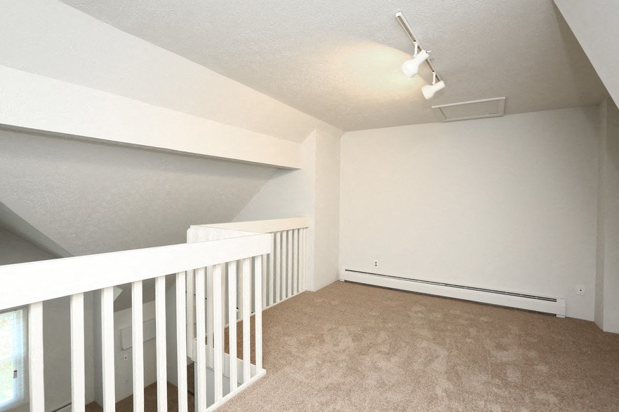 an empty room with a staircase and white walls
