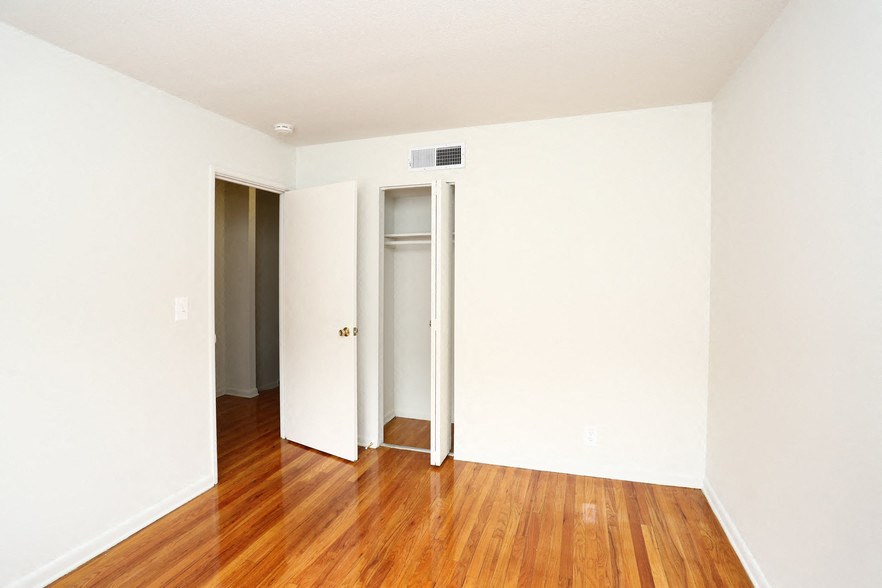 an empty room with a wood floor and white walls