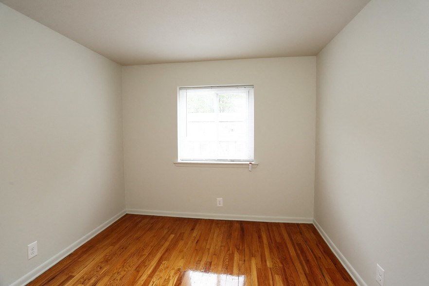 an empty room with wooden floors and a window