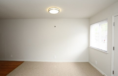 a bedroom with white walls and a large window