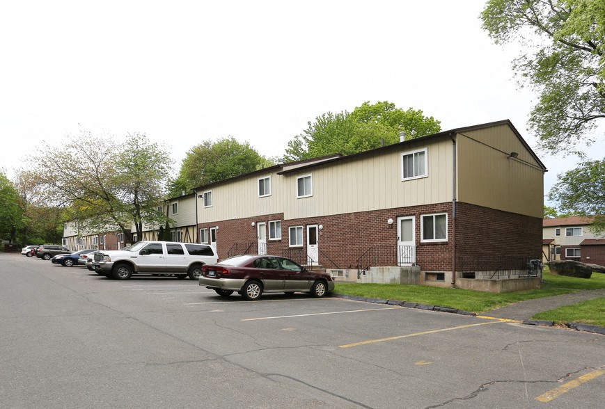an apartment building with cars parked in a parking lot