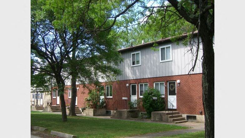 a red brick house with trees in front of it