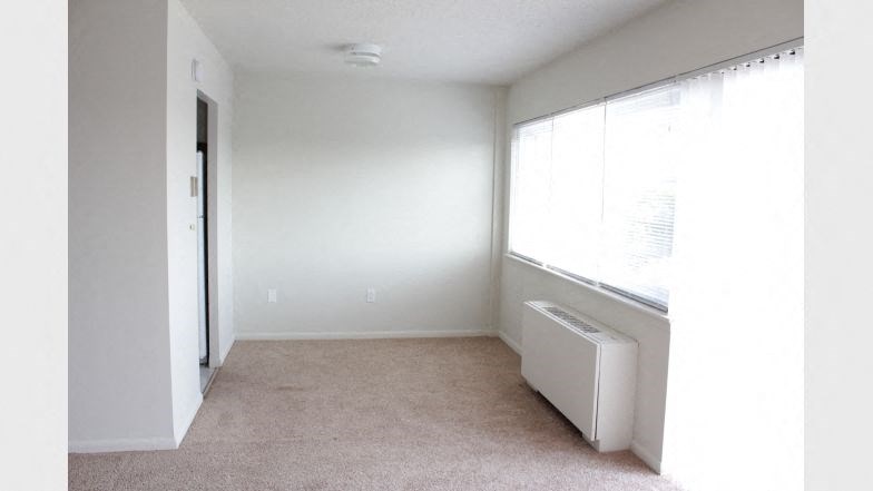 an empty room with a window and a radiator