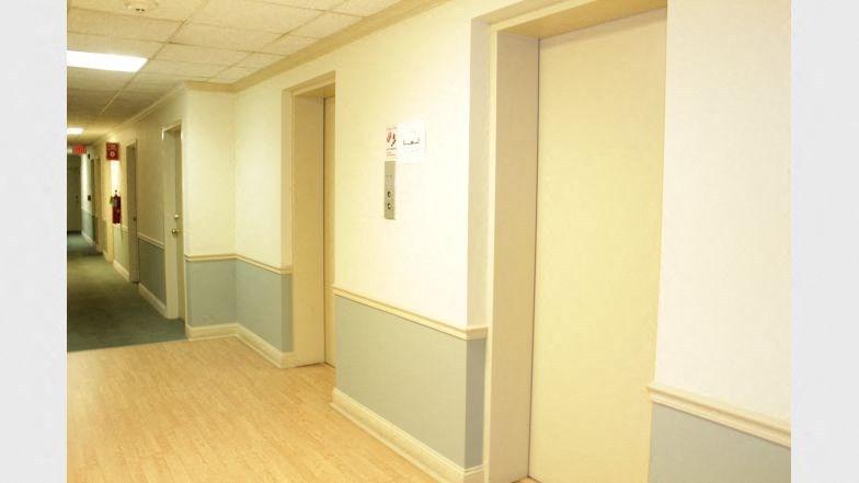 a hospital hallway with doors and a sign on the wall