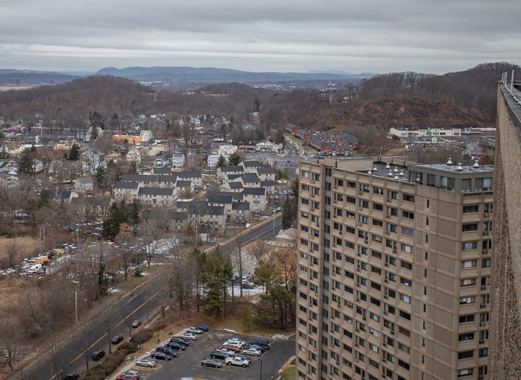 an aerial view of a city with a tall building and a parking lot