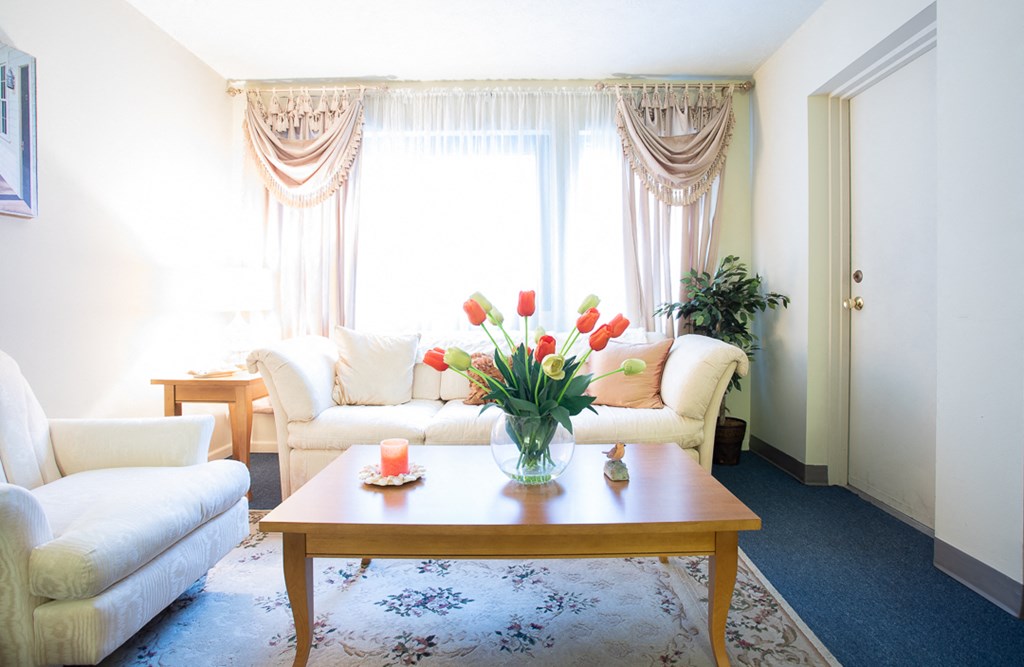 a living room with couches and a table with flowers