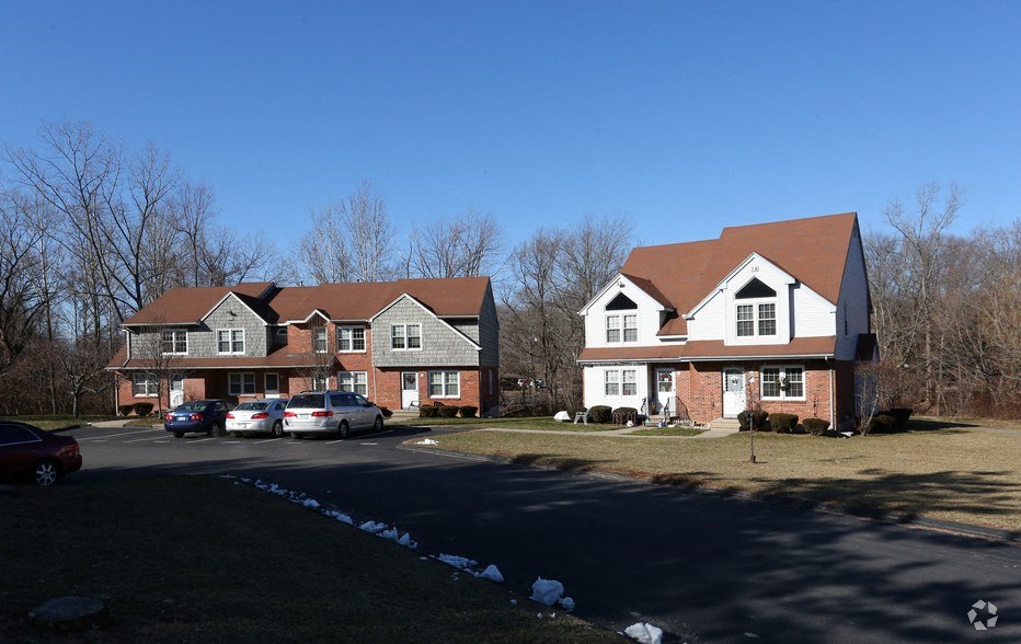 a group of houses in a neighborhood with cars parked in a driveway