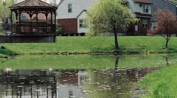 a pond with a house and a gazebo