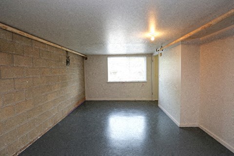 an empty room with a window and a black floor