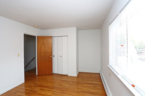 an empty room with a wood floor and a closet