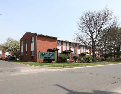 an empty street in front of a brick apartment building
