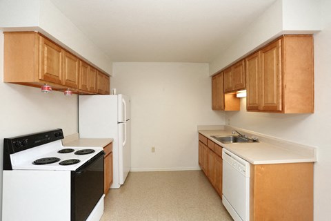 an empty kitchen with a stove refrigerator and sink