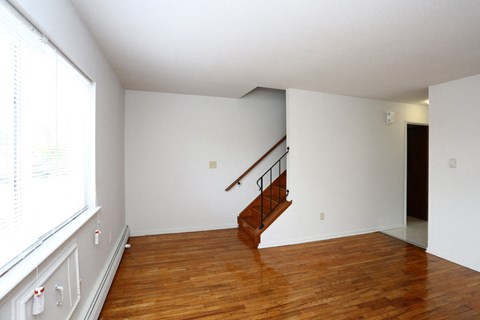 a living room with a wood floor and a staircase
