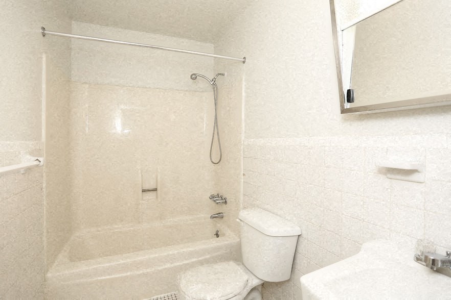 a white bathroom with a shower and a toilet