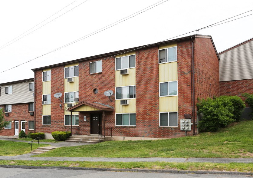 a red brick apartment building with yellow curtains on the windows