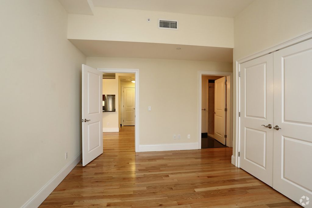 a living room with wood floors and white doors