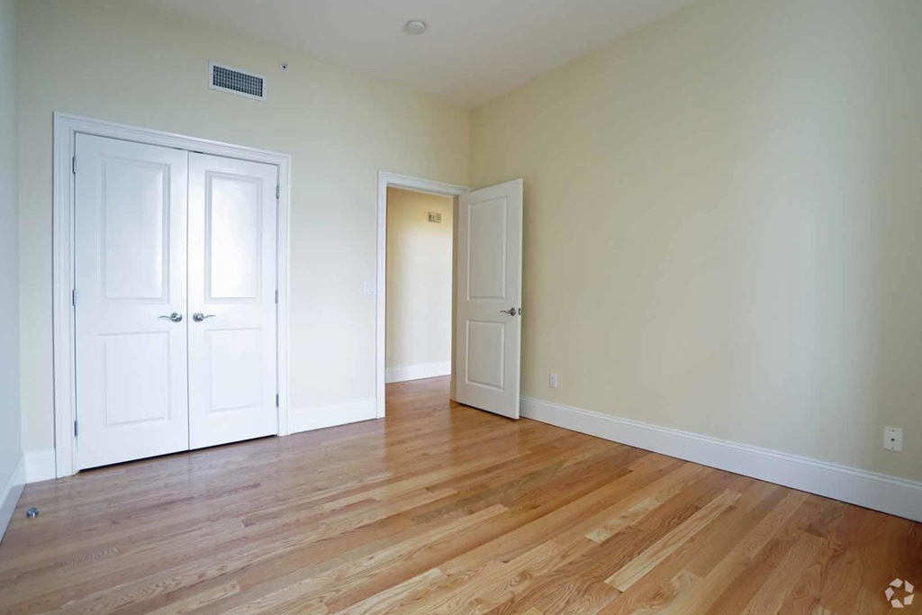 a living room with two doors and a wood floor