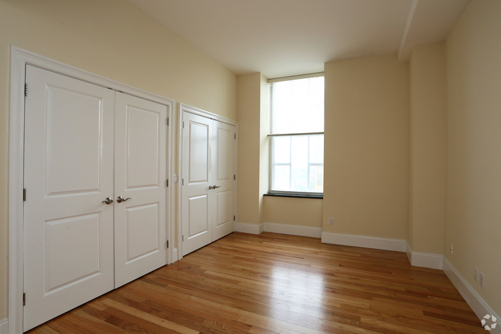 an empty room with white doors and a window