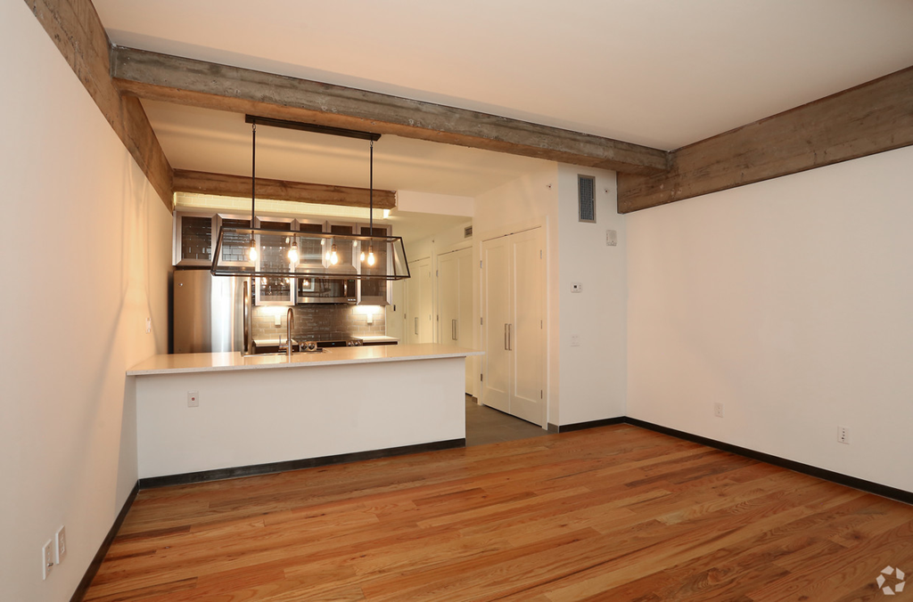 a living room with a kitchen and a wood floor
