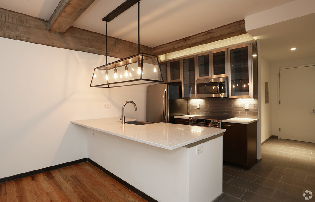 a kitchen with a white counter top and a sink
