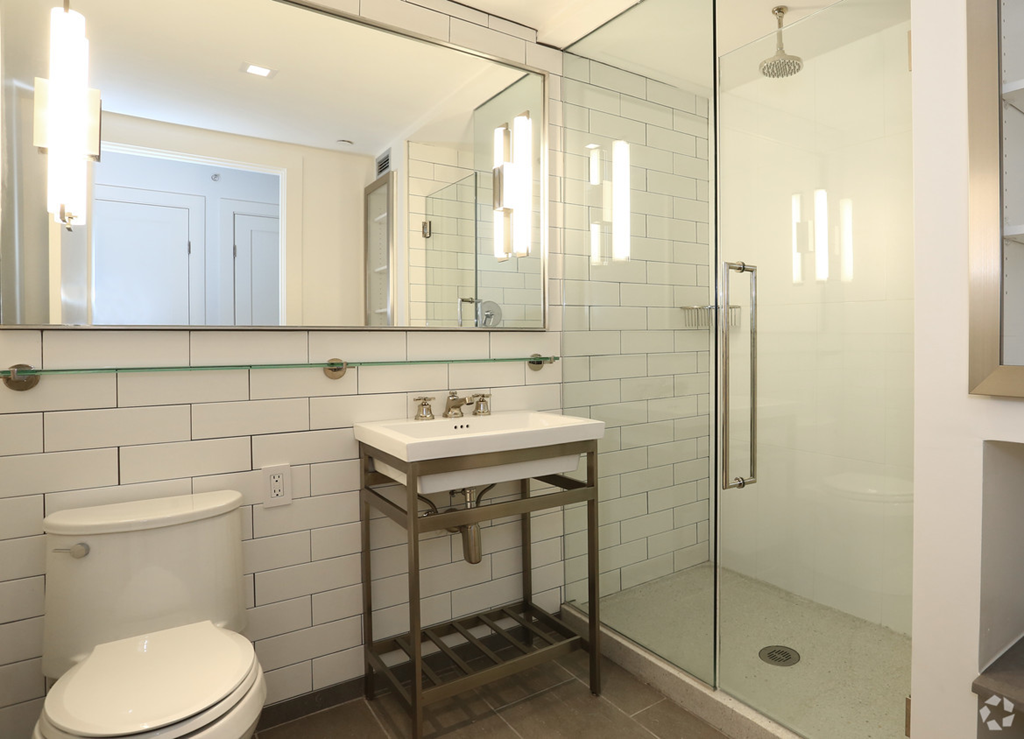 a white bathroom with a sink and toilet and a shower