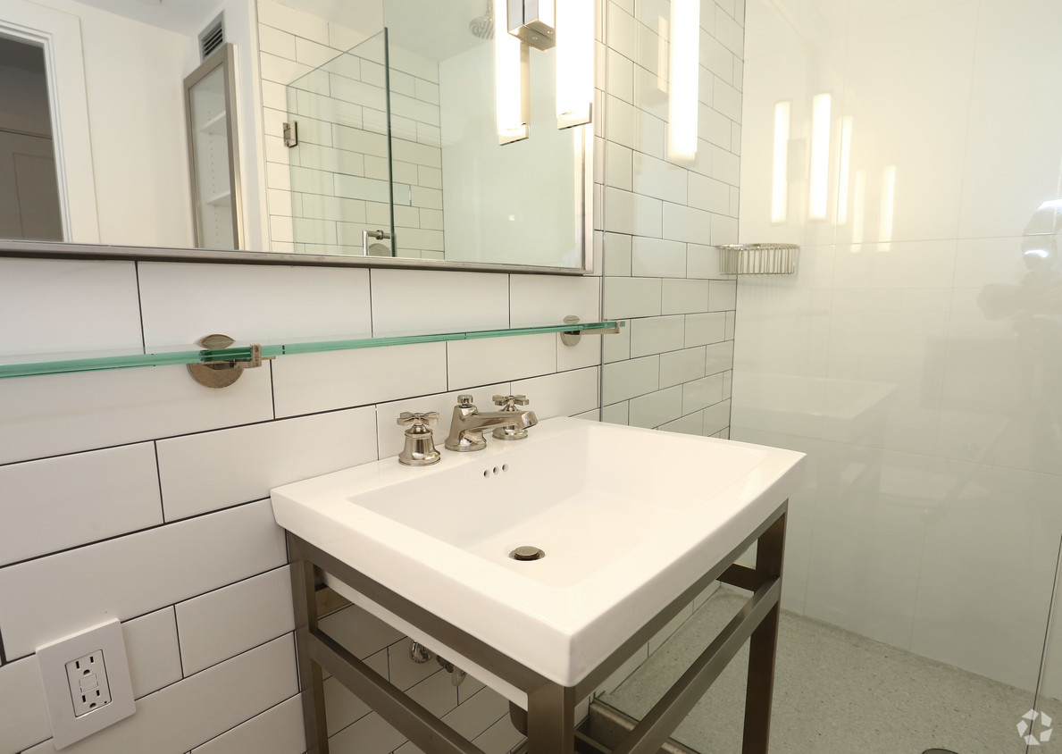 a white bathroom with a sink and a mirror