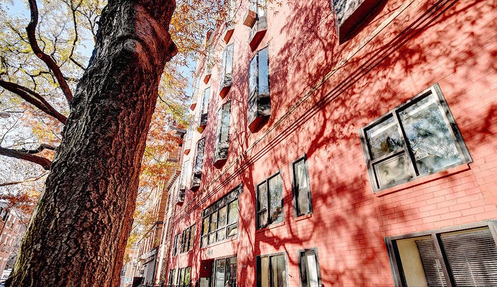 a red brick building with a tree in front of it