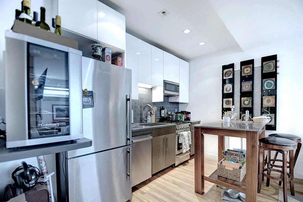 a kitchen with stainless steel appliances and a wooden table