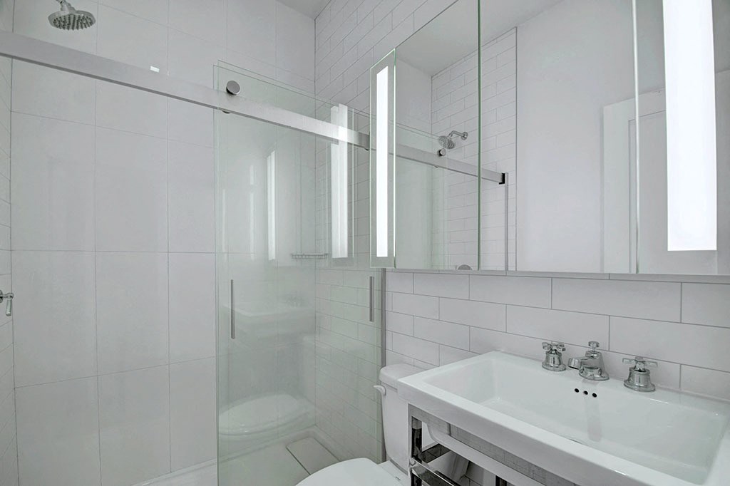 a white bathroom with a sink and a shower