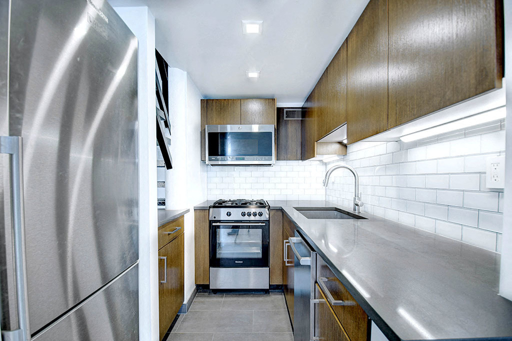 a modern kitchen with stainless steel appliances and wooden cabinets