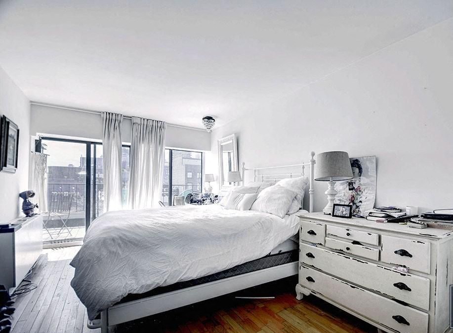 a white bedroom with a bed and a dresser
