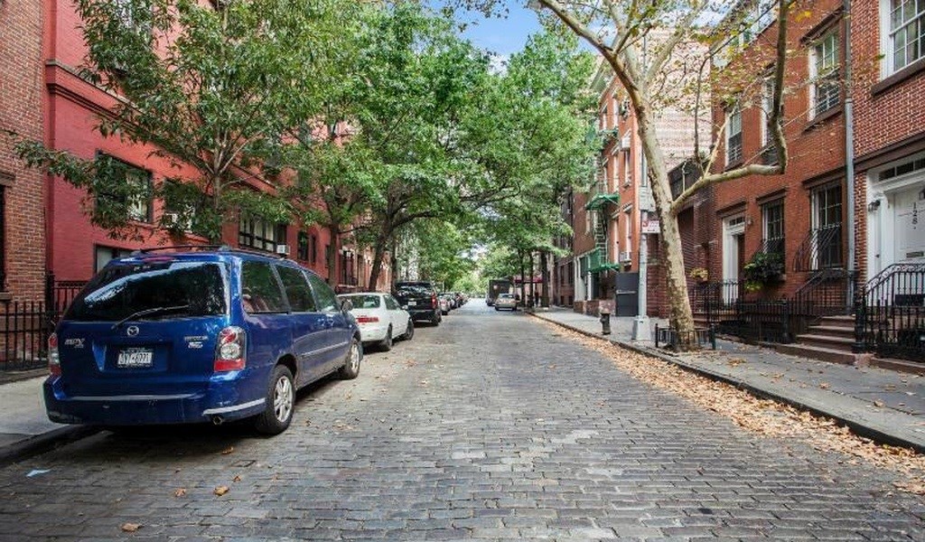 a cobblestone street with a blue van parked on it