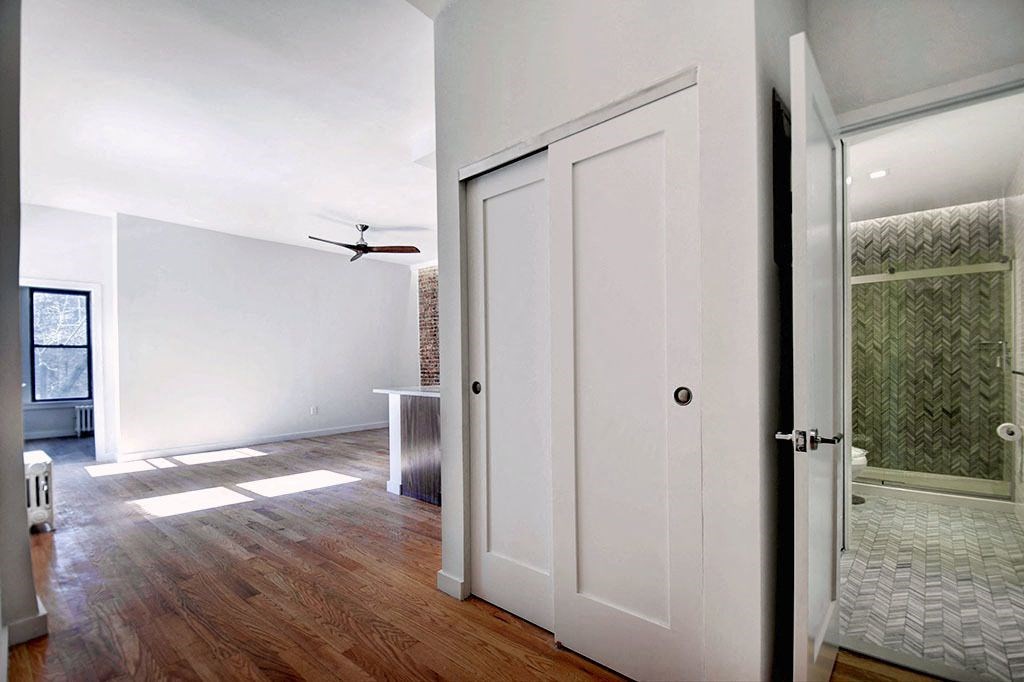 an empty room with a closet and a ceiling fan