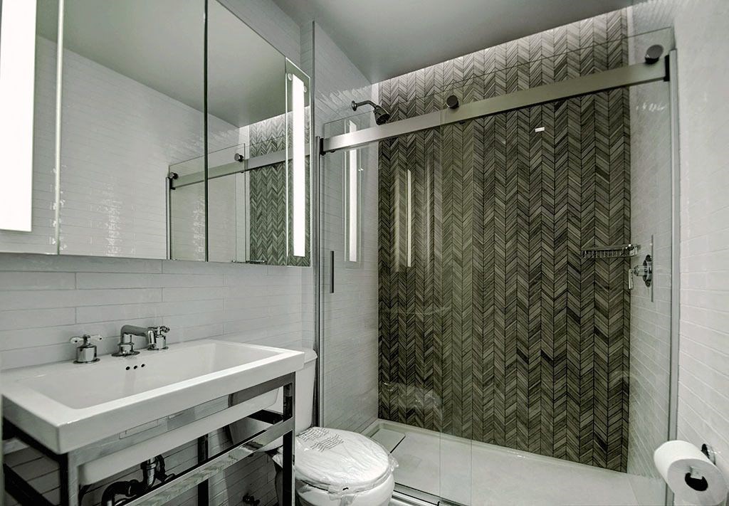 a bathroom with a shower and a sink and a mirror