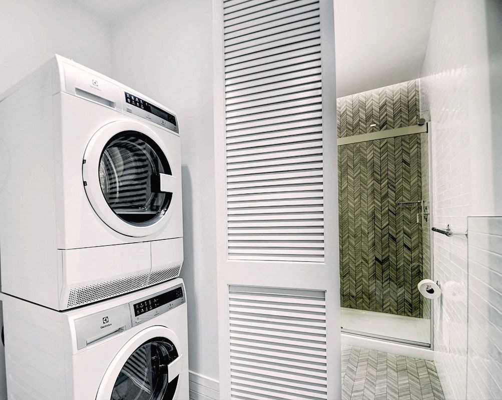 a washer and dryer in a bathroom with a shower