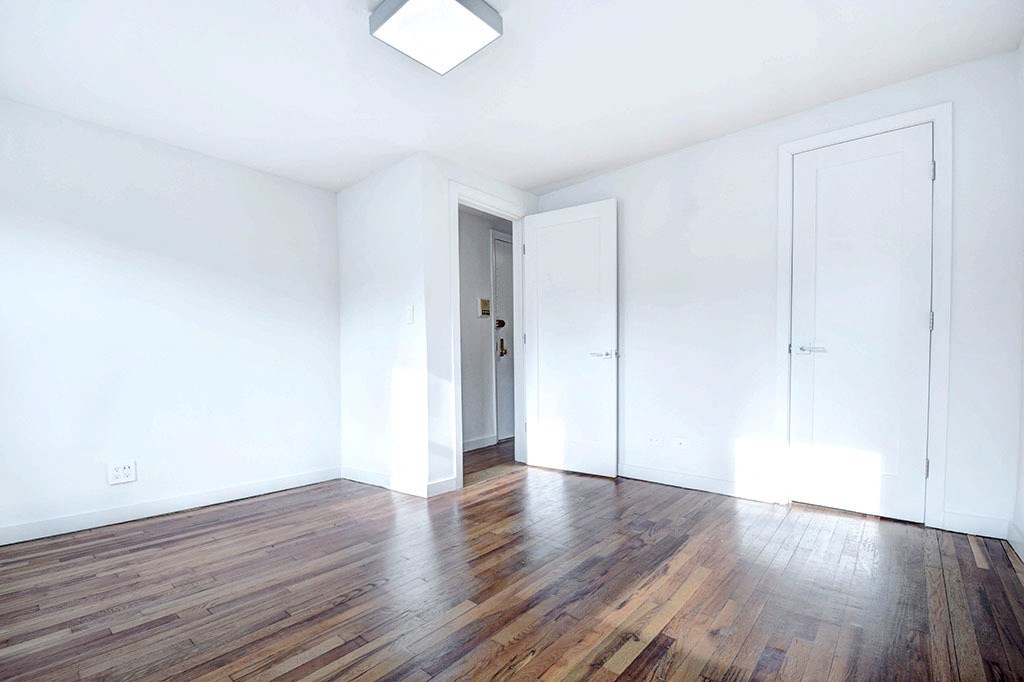 an empty living room with white walls and wood floors