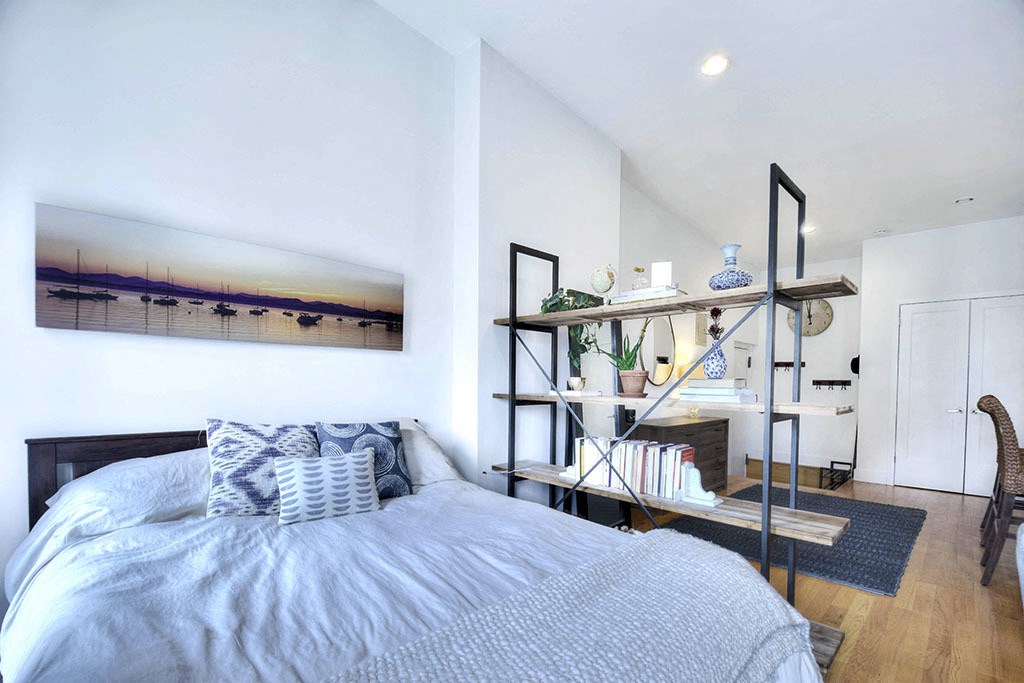 a bedroom with a bed and a book shelf next to it